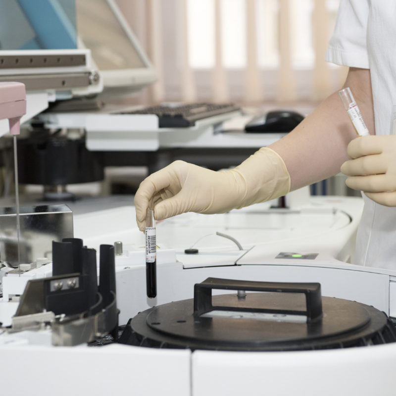 of a woman wearing gloves holding a test tube