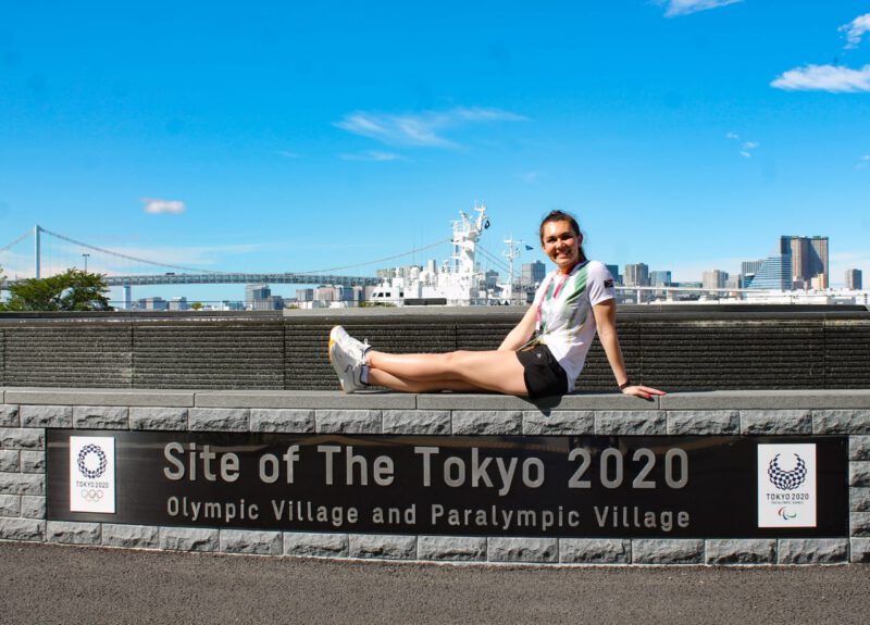 Alani Ferreira sitting on the wall at the Site of the Tokyo 2020 Olympic Village