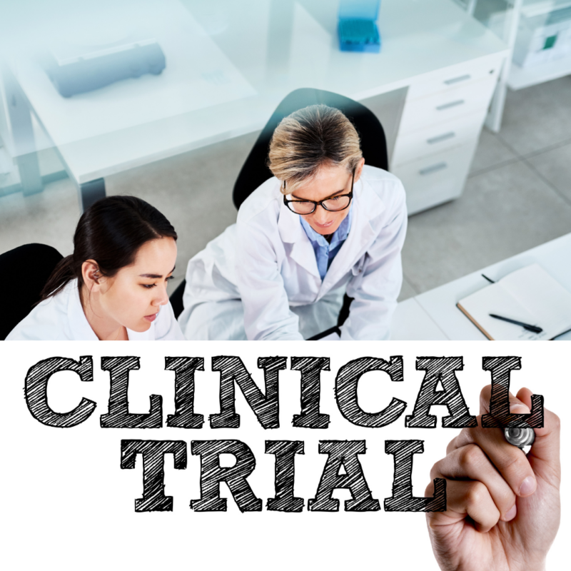 of two women researches in a laboratory with the words Clinical Trial underneath in Black lettering