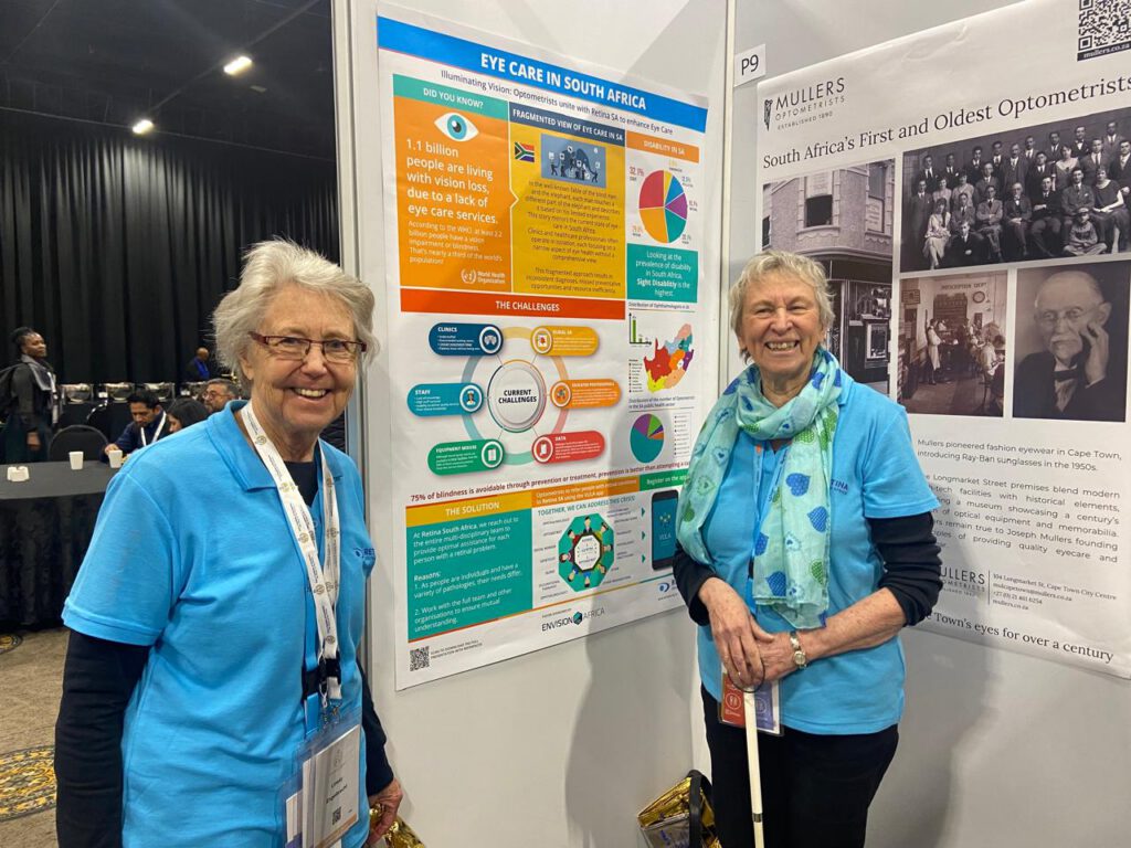 Karen Denton (left) and Claudette Medefindt (right) at the conference wearing their blue Retina SA shirts standing in front of a poster titled ‘EYE CARE IN SOUTH AFRICA’