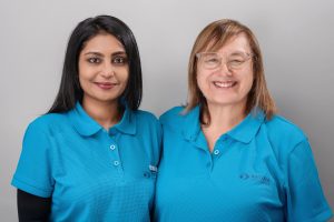 Sonya (pictured left) and Caryl (pictured right) both smiling and wearing blue Retina branded shirts