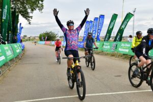 cyclist raising arms crossing finsh line